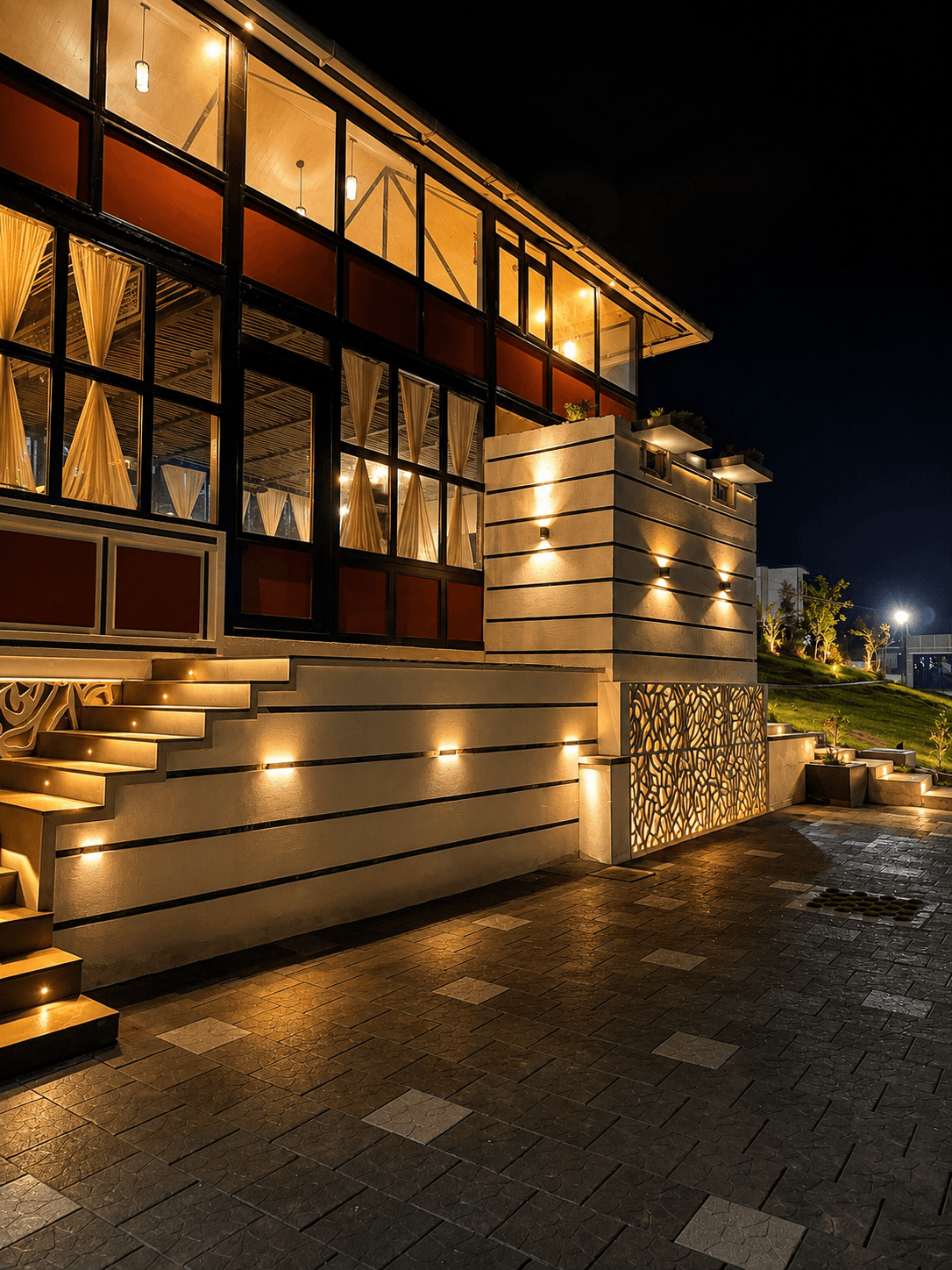 Glass-fronted resort pavilion illuminated at night
